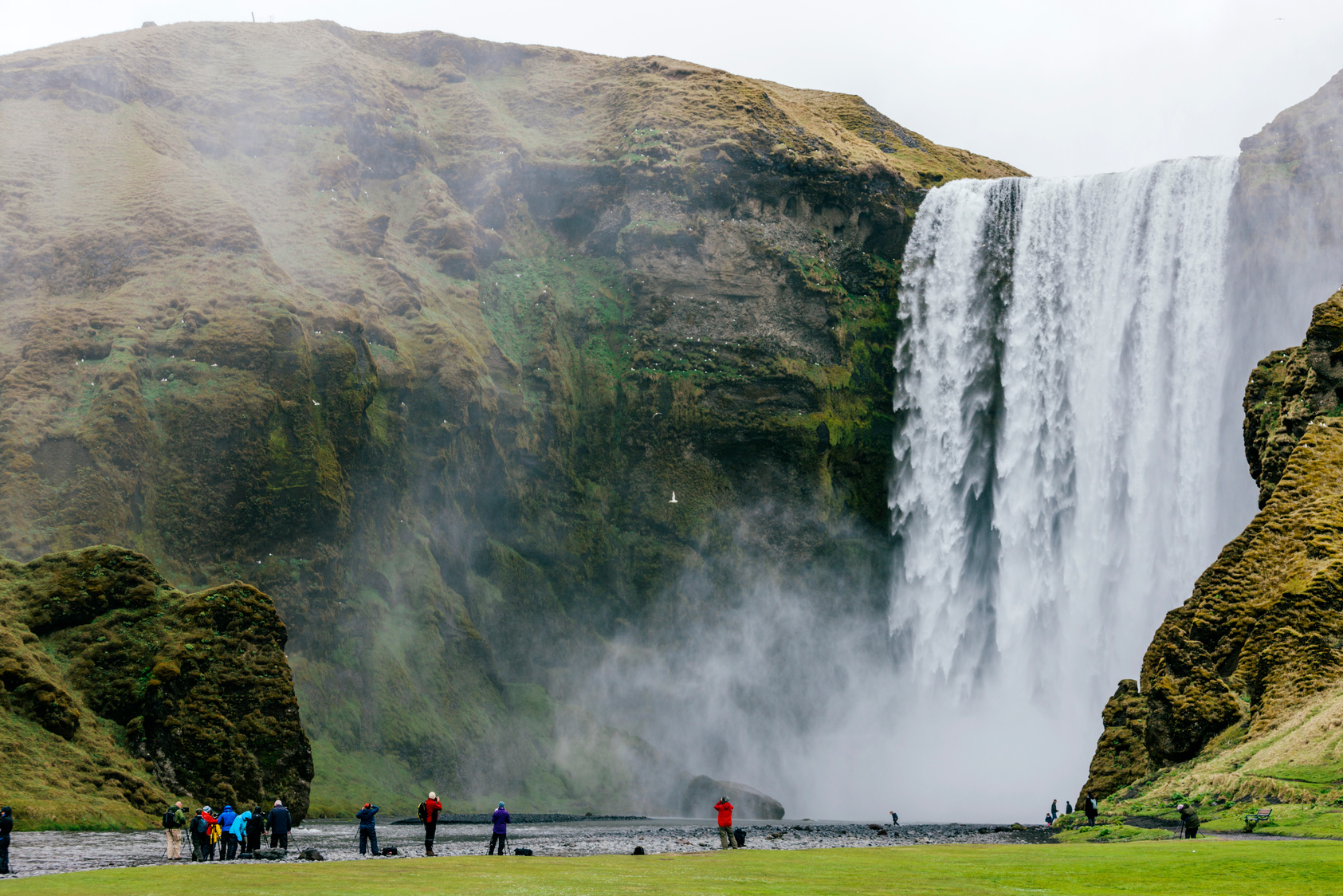 Skógafoss, tourists stand at Skógafoss waterfall, Iceland